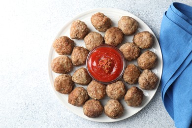 Photo of Delicious meatballs with ketchup and spices on light textured table, flat lay