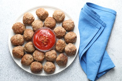 Photo of Delicious meatballs with ketchup and spices on light textured table, flat lay