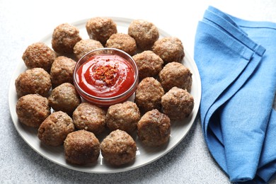 Photo of Delicious meatballs with ketchup and spices on light textured table, closeup