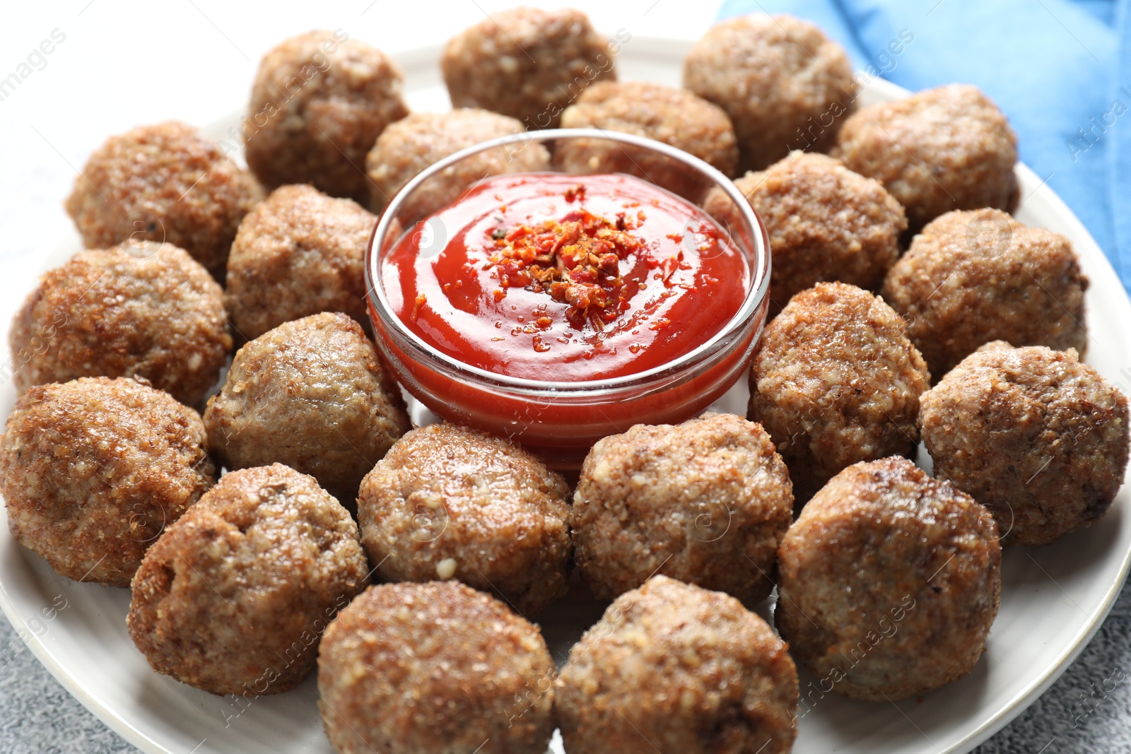 Photo of Delicious meatballs with ketchup and spices on table, closeup