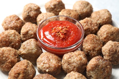 Photo of Delicious meatballs with ketchup and spices on plate, closeup