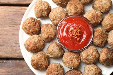 Photo of Delicious meatballs with ketchup and spices on wooden table, top view