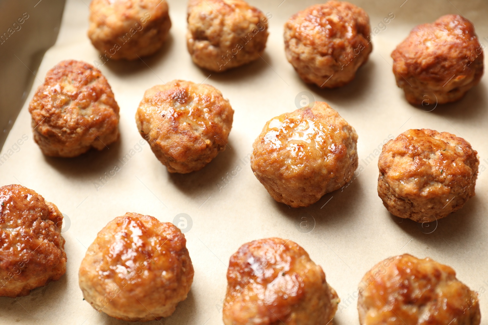 Photo of Many delicious meatballs on parchment, closeup view