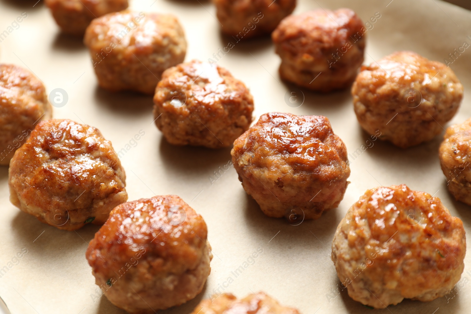 Photo of Many delicious meatballs on parchment, closeup view