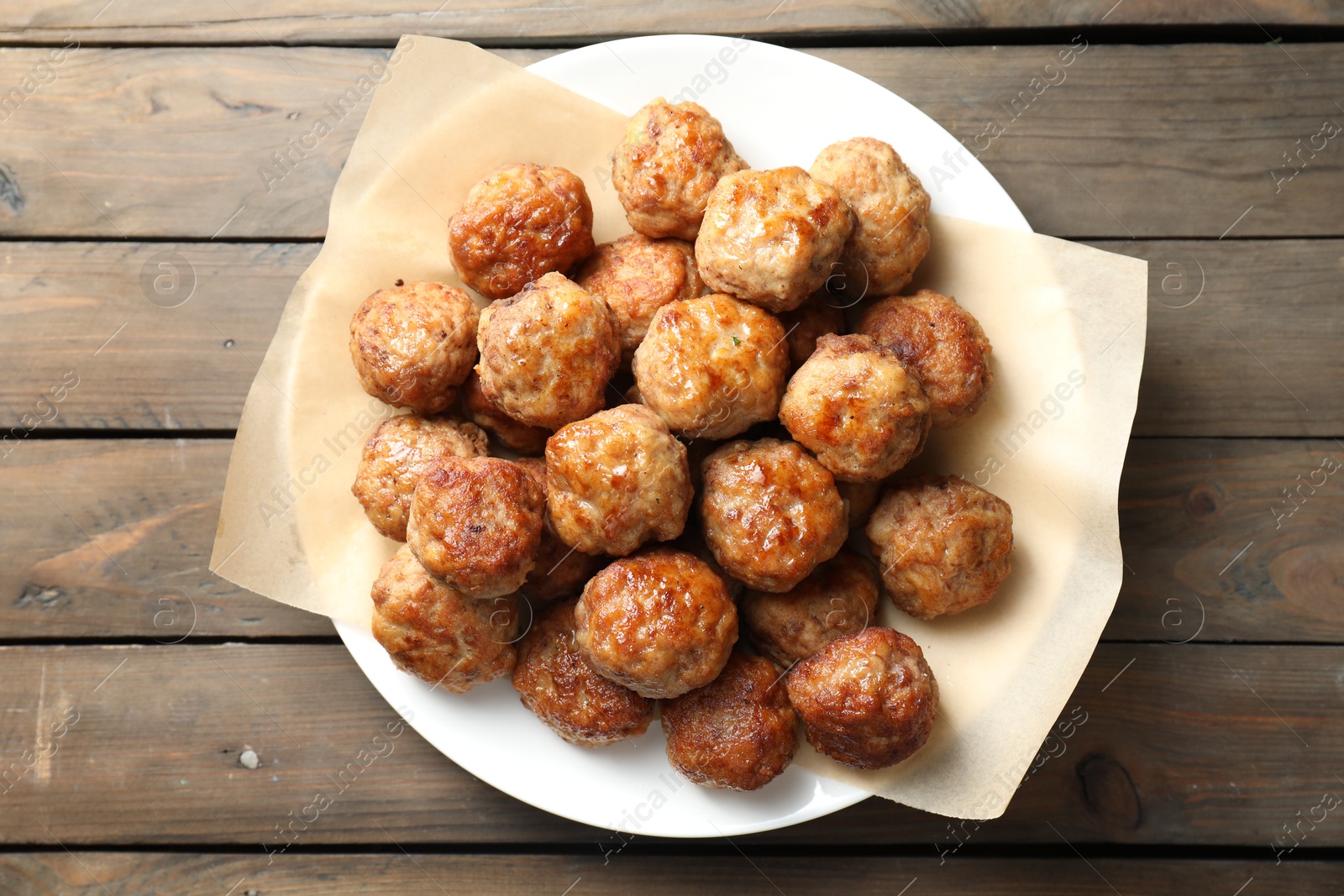 Photo of Many delicious meatballs on wooden table, top view