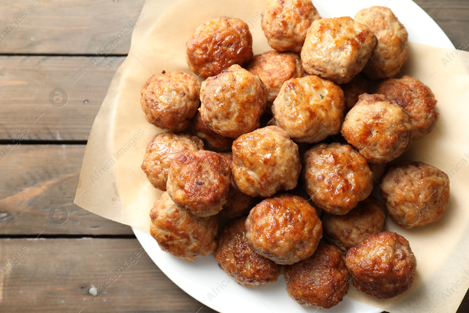 Photo of Many delicious meatballs on wooden table, top view