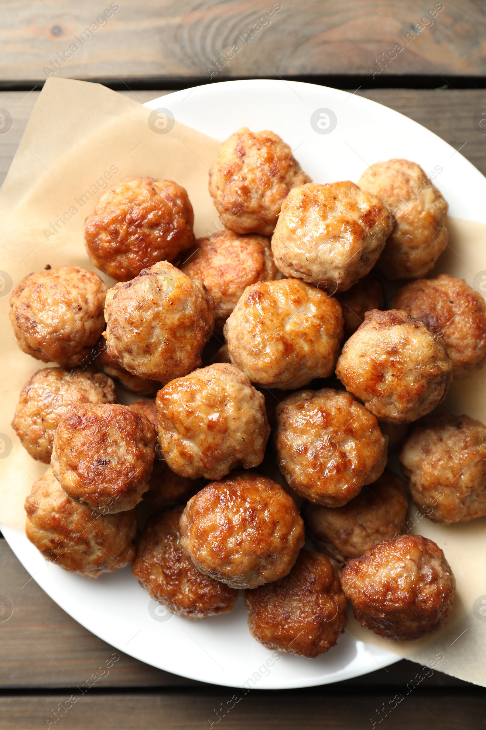 Photo of Many delicious meatballs on wooden table, top view