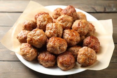 Photo of Many delicious meatballs on wooden table, closeup