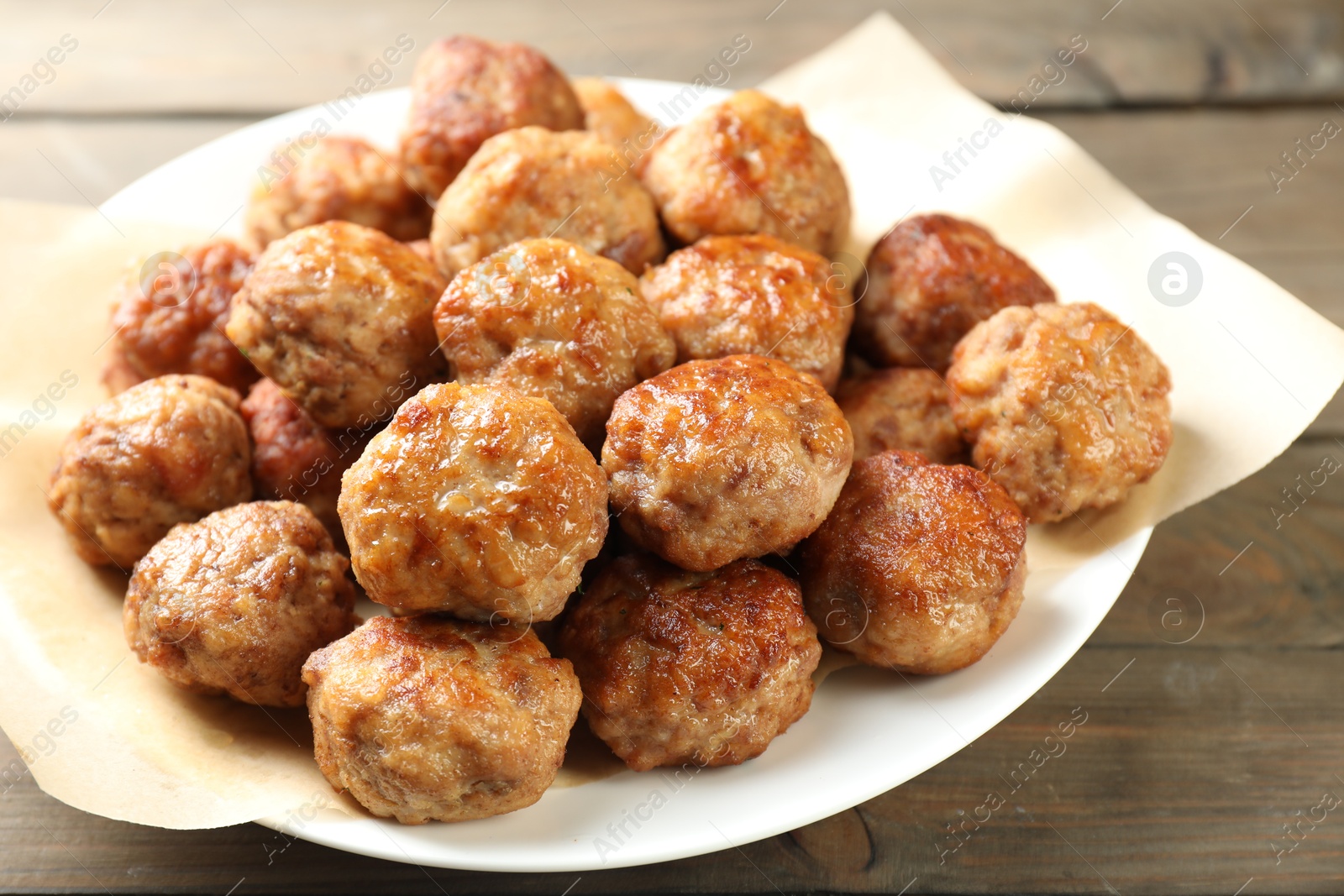 Photo of Many delicious meatballs on wooden table, closeup