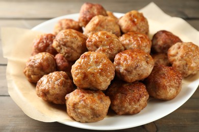 Photo of Many delicious meatballs on wooden table, closeup