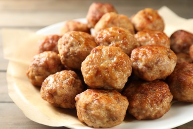 Photo of Many delicious meatballs on wooden table, closeup