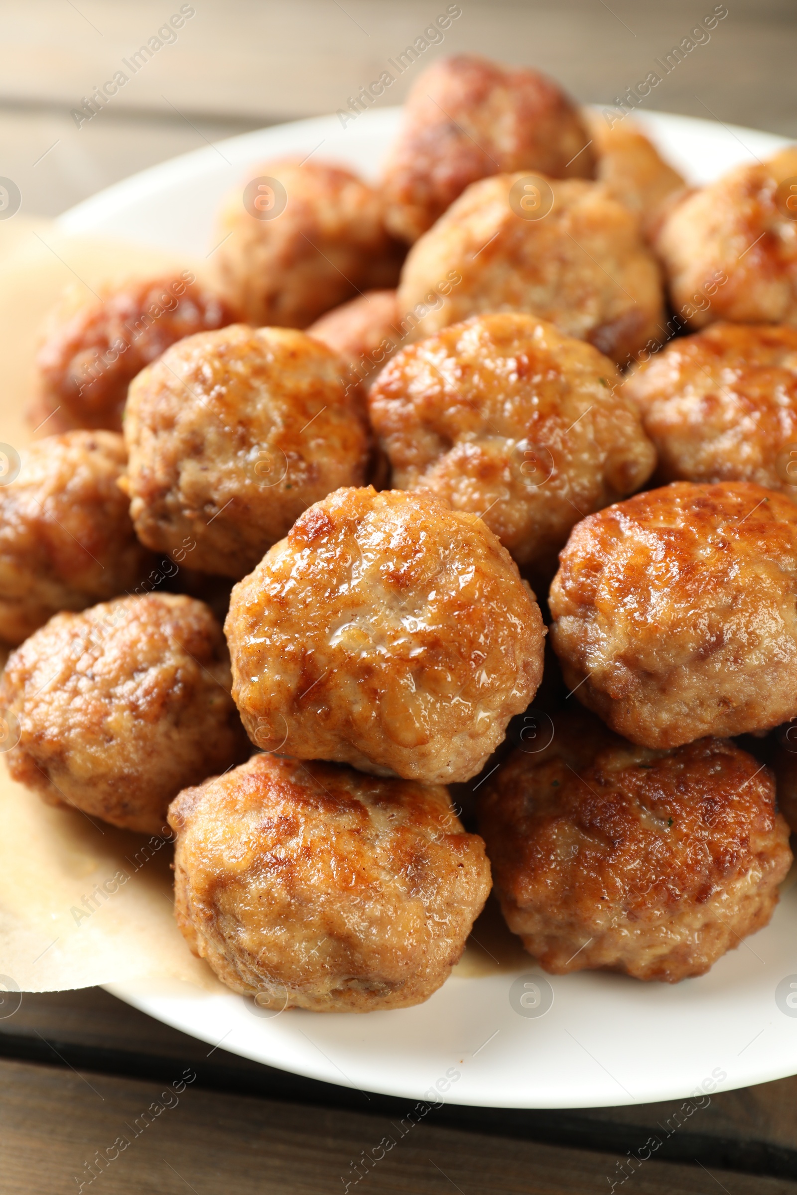 Photo of Many delicious meatballs on wooden table, closeup