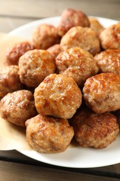 Photo of Many delicious meatballs on wooden table, closeup