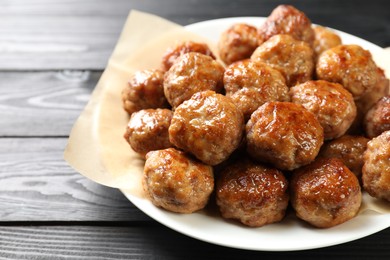 Photo of Many delicious meatballs on dark wooden table, closeup