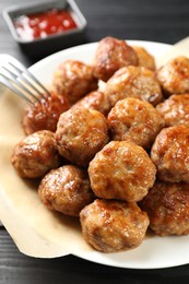 Photo of Many delicious meatballs on dark wooden table, closeup