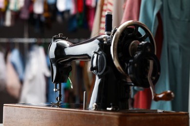 Photo of Vintage sewing machine with thread in workshop, closeup