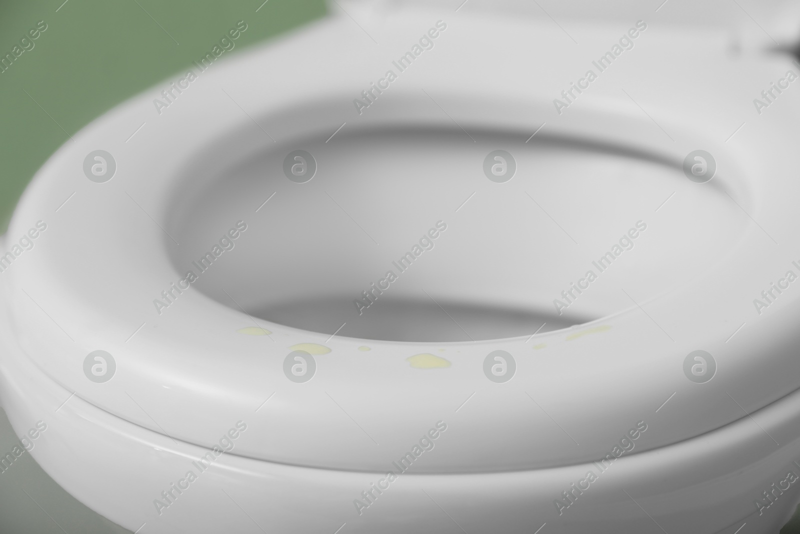 Photo of Urine drops on toilet seat in restroom, closeup