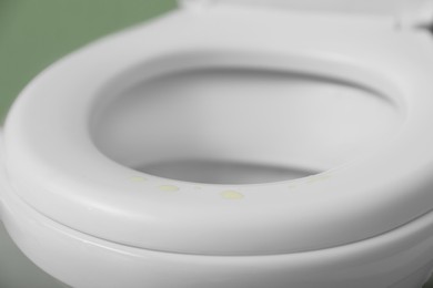 Urine drops on toilet seat in restroom, closeup