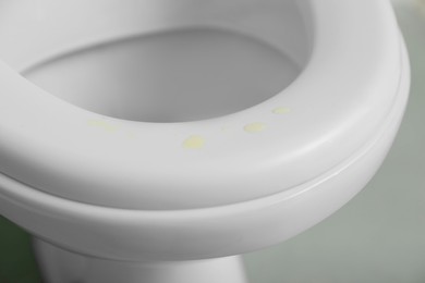 Urine drops on toilet seat in restroom, closeup