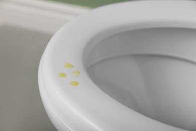 Photo of Urine drops on toilet seat in restroom, closeup