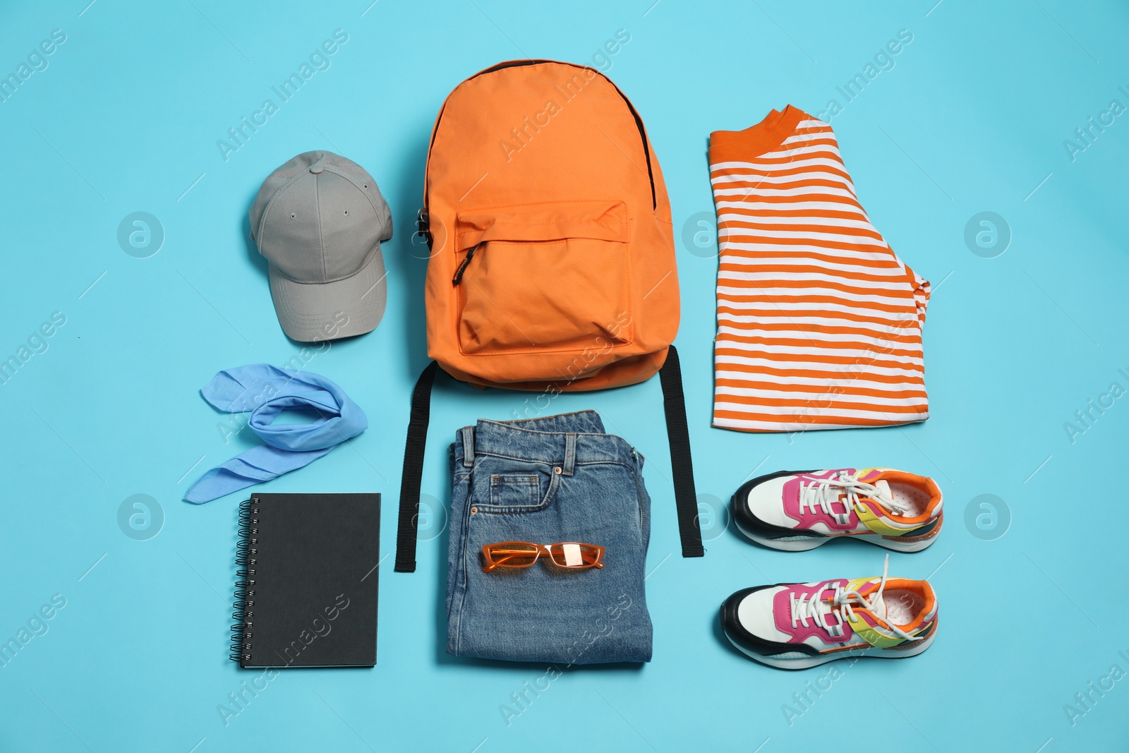 Photo of Stylish outfit with backpack on light blue background, flat lay