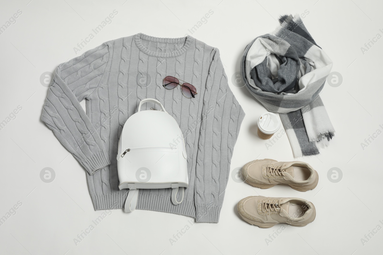 Photo of Stylish outfit with backpack on white background, flat lay