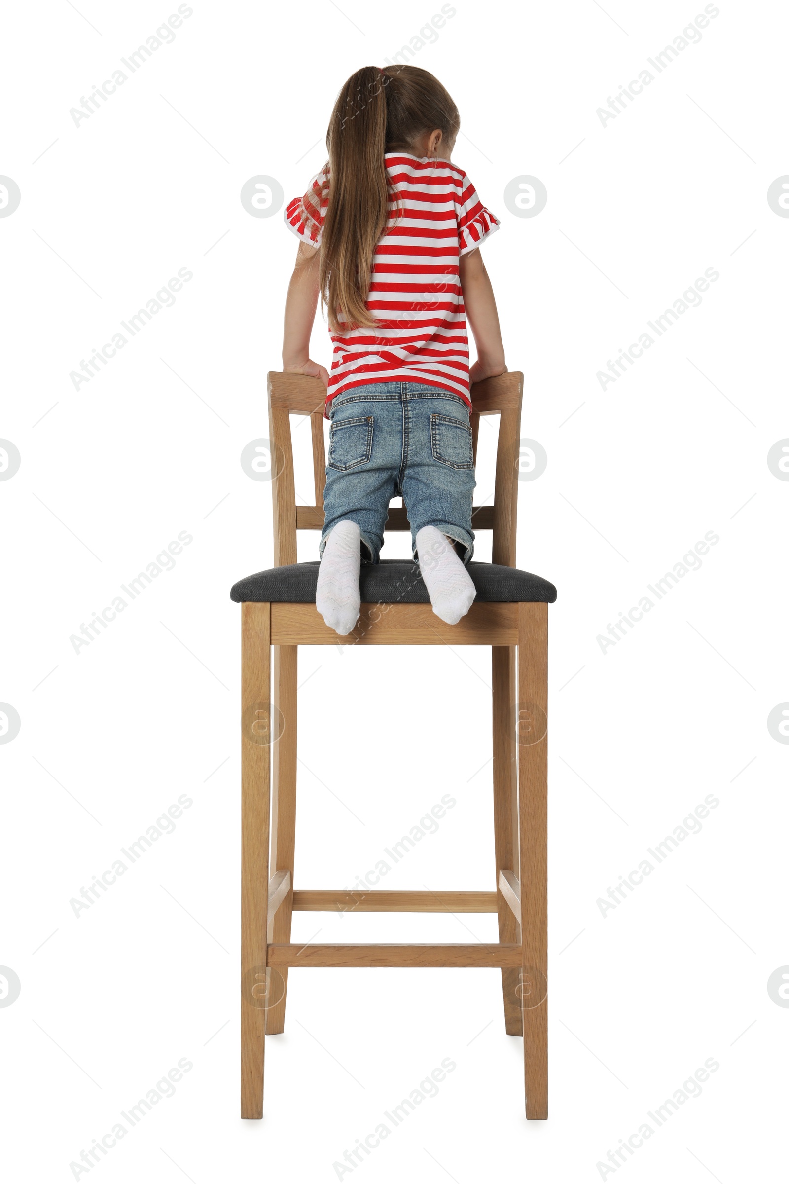 Photo of Little girl sitting on stool against white background, back view