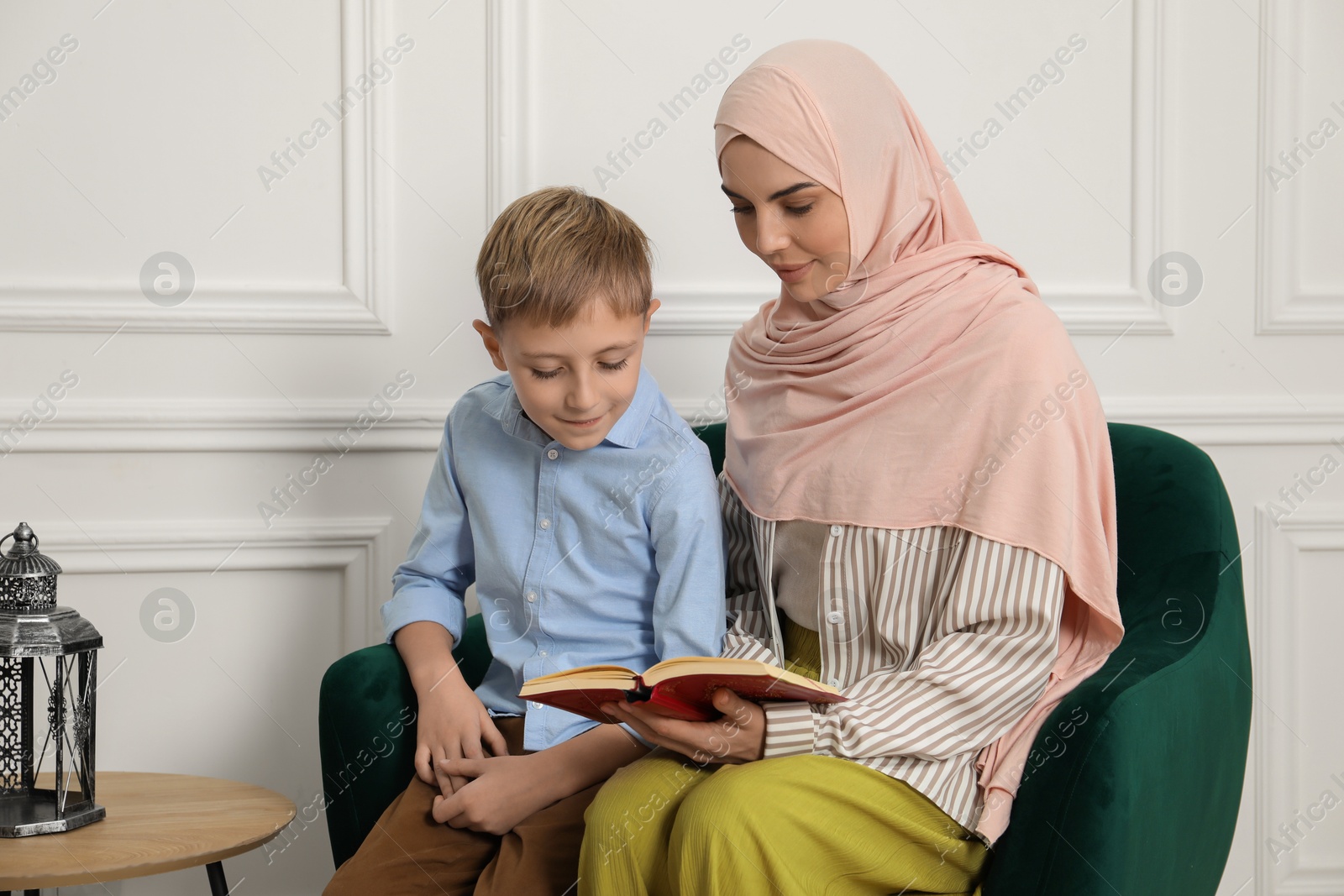 Photo of Muslim woman and her son spending time together at home