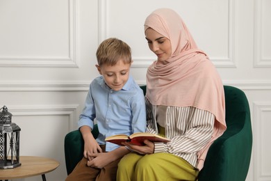 Photo of Muslim woman and her son spending time together at home