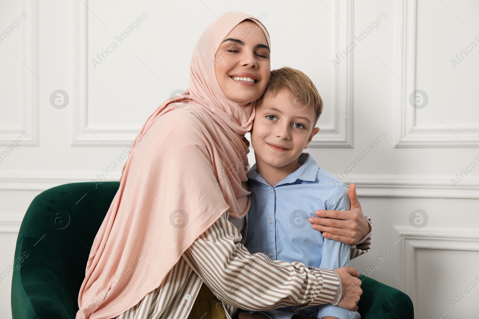 Photo of Muslim woman and her son spending time together at home