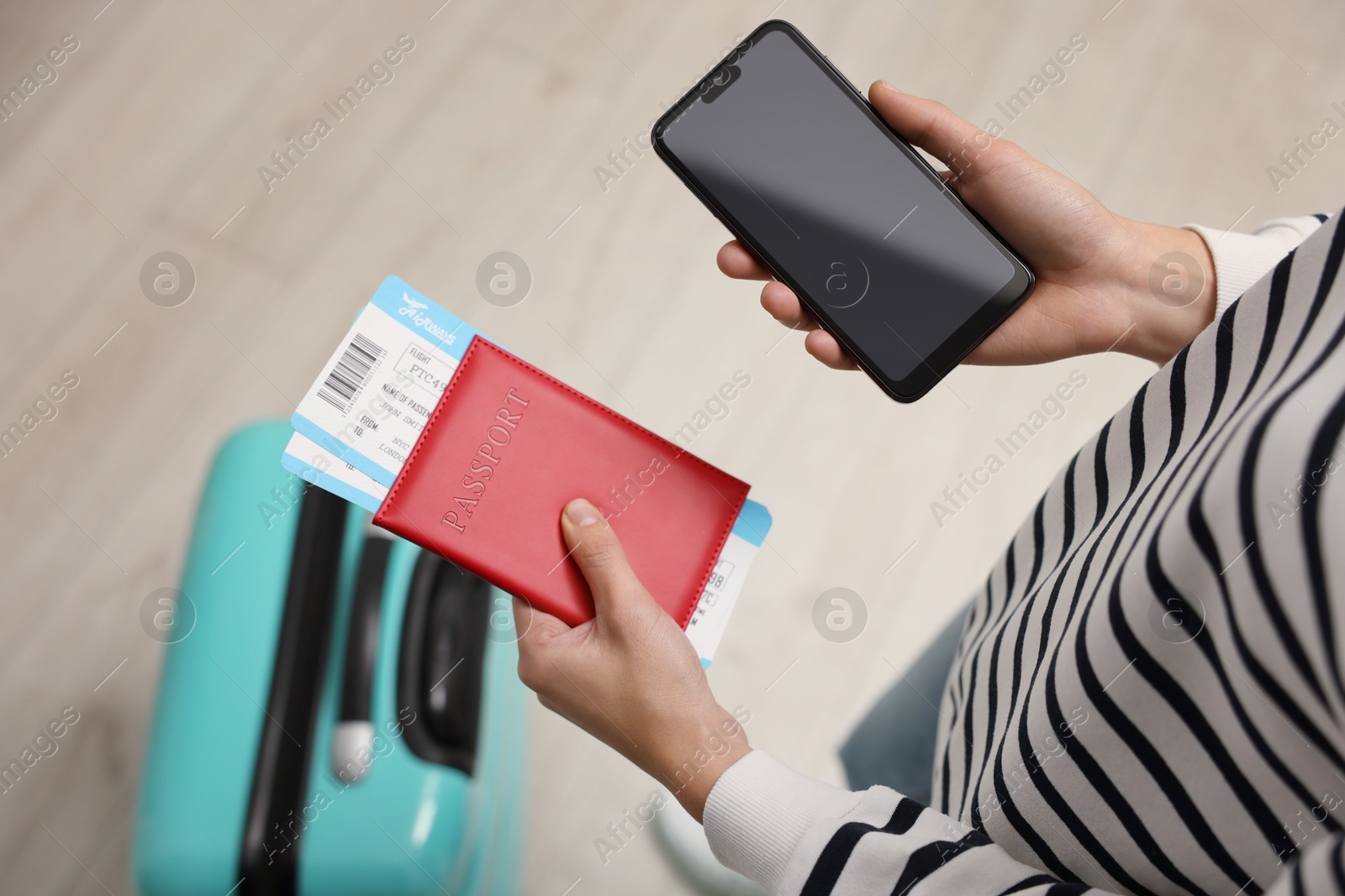 Photo of Traveller with passport, flight tickets and smartphone indoors, top view