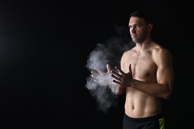 Photo of Man clapping hands with talcum powder before training on black background. Space for text