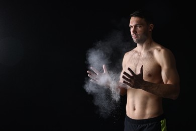 Photo of Man clapping hands with talcum powder before training on black background. Space for text