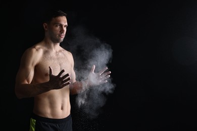 Photo of Man clapping hands with talcum powder before training on black background. Space for text