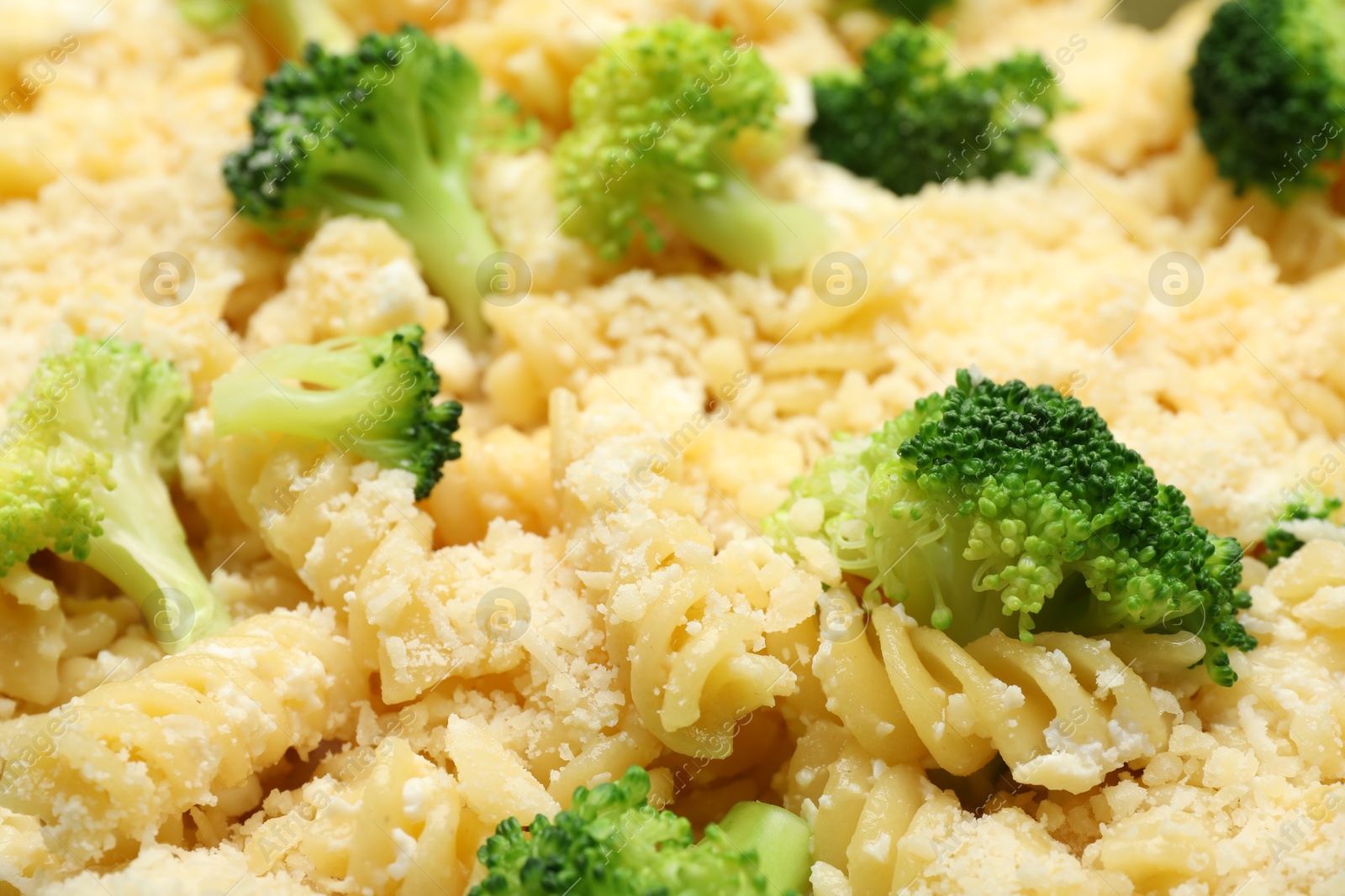 Photo of Uncooked pasta casserole with cheese and broccoli as background, closeup