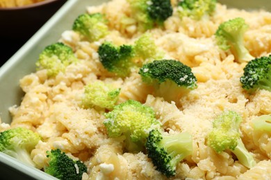 Photo of Uncooked pasta casserole with cheese and broccoli in baking dish on table, closeup