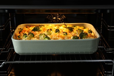 Photo of Baking dish with tasty pasta casserole in oven, closeup