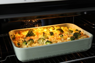 Photo of Baking dish with tasty pasta casserole in oven, closeup