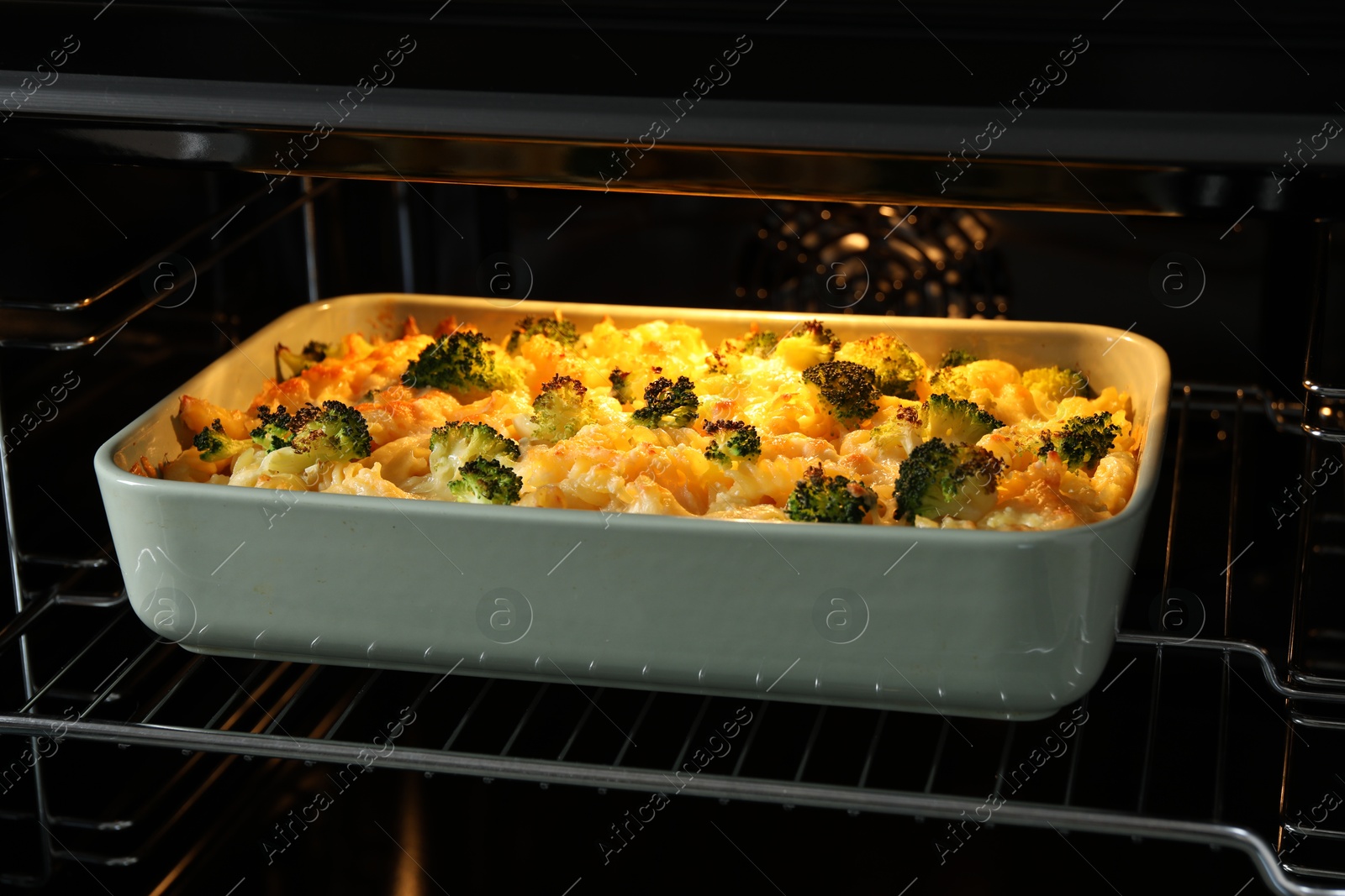 Photo of Baking dish with tasty pasta casserole in oven, closeup