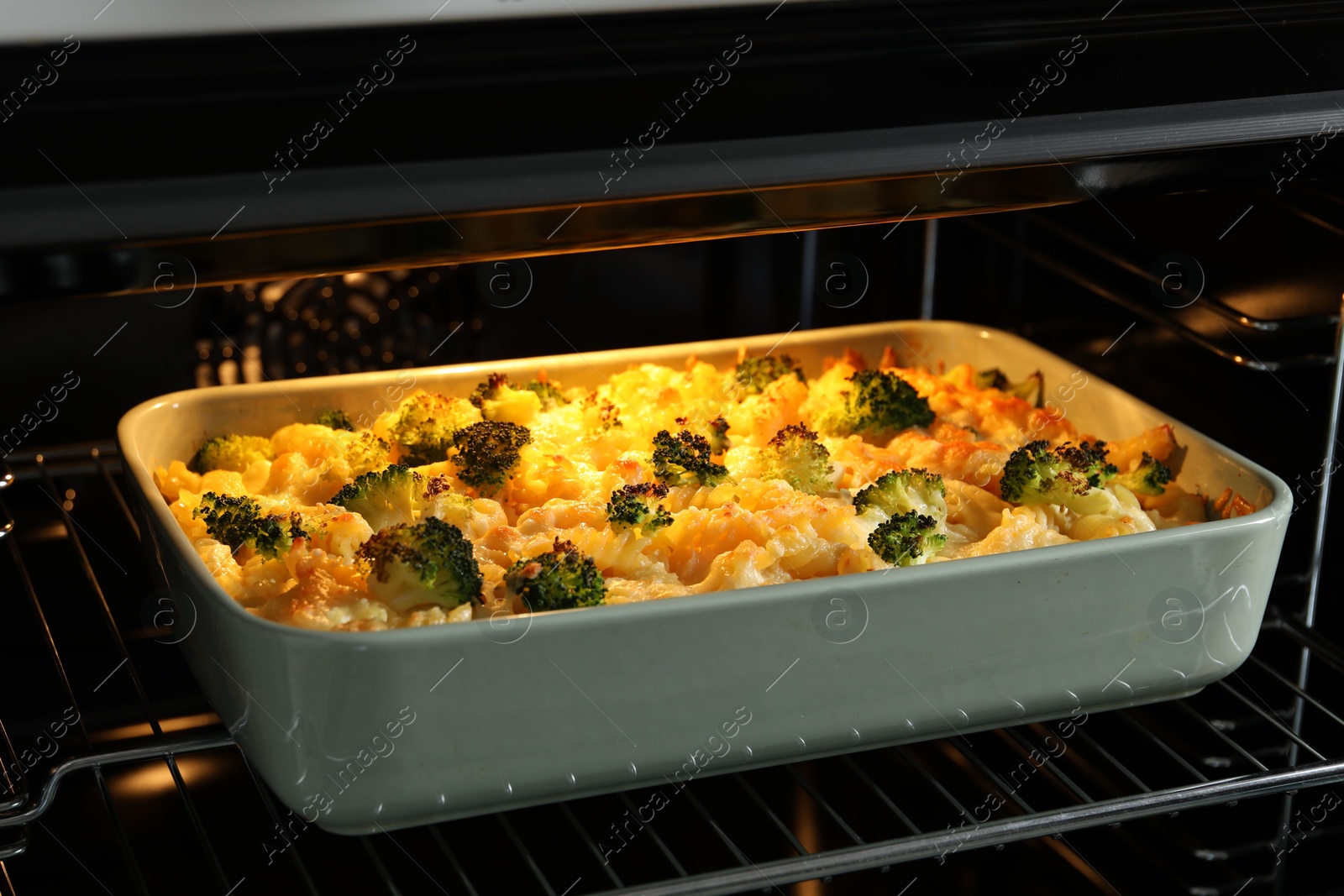 Photo of Baking dish with tasty pasta casserole in oven, closeup