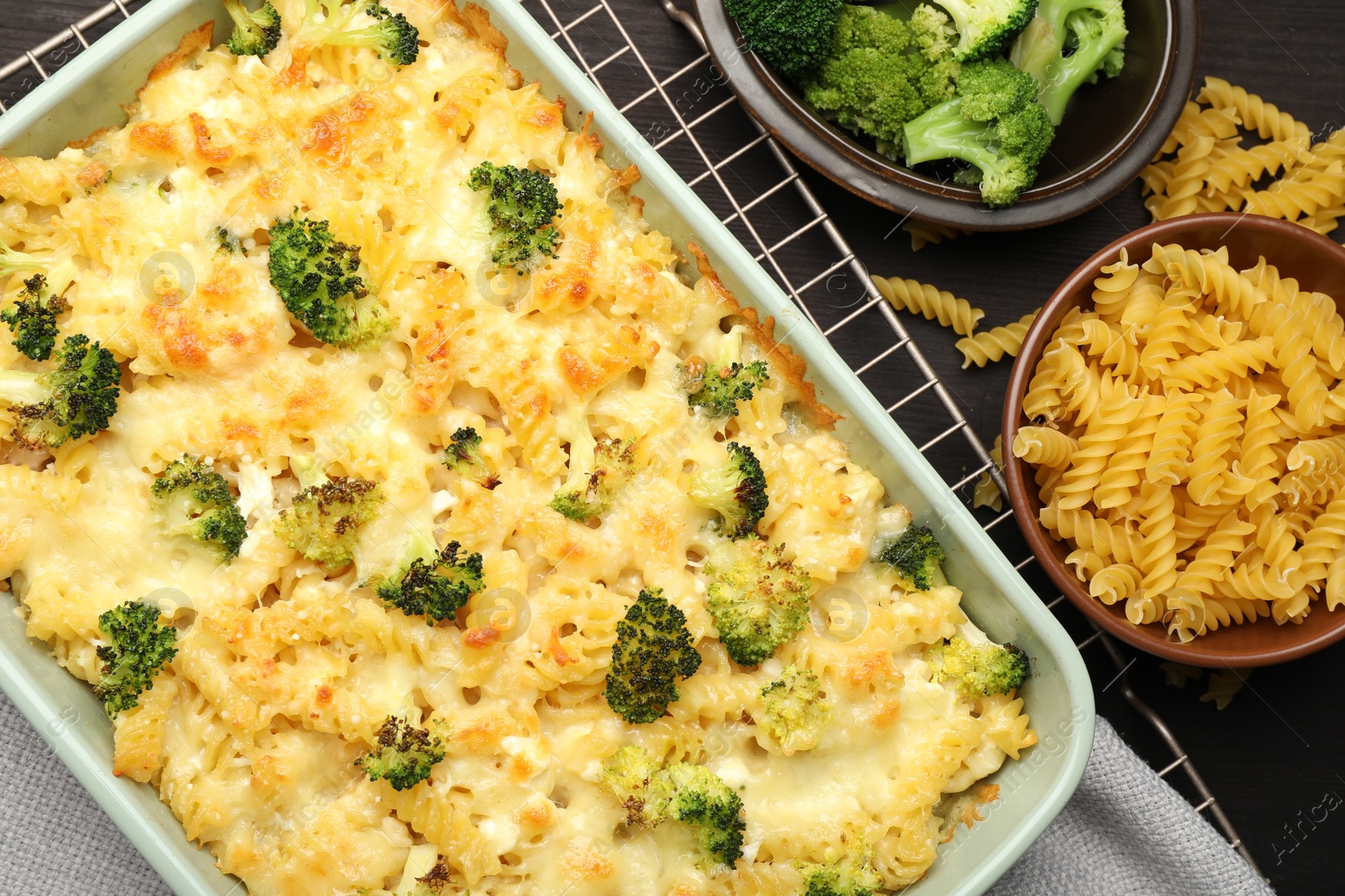 Photo of Tasty pasta casserole with cheese and broccoli on wooden table, flat lay