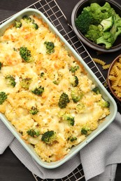 Photo of Tasty pasta casserole with cheese and broccoli on wooden table, flat lay