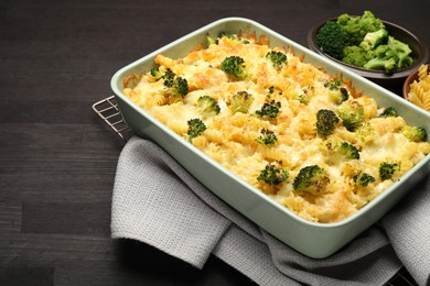 Photo of Tasty pasta casserole with cheese and broccoli in baking dish on wooden table, closeup