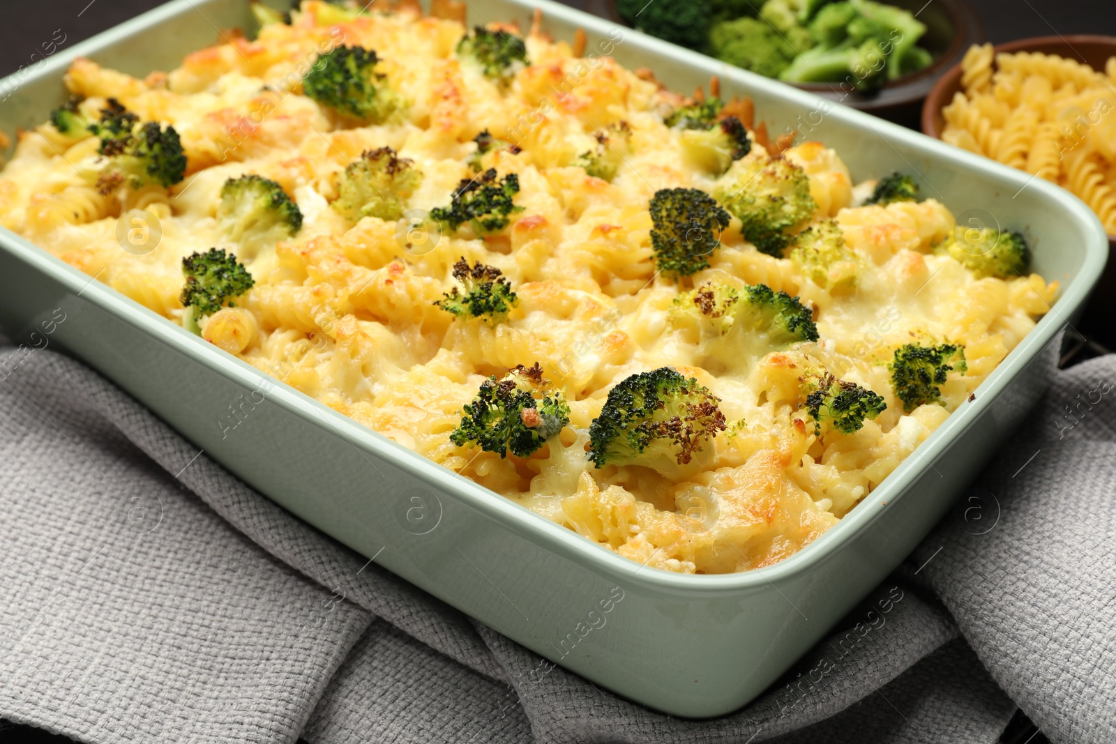 Photo of Tasty pasta casserole with cheese and broccoli in baking dish on table, closeup