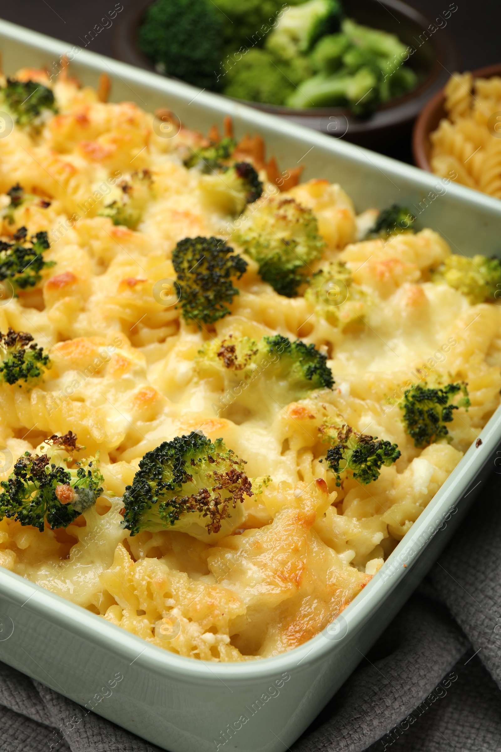 Photo of Tasty pasta casserole with cheese and broccoli in baking dish on table, closeup