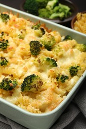 Photo of Tasty pasta casserole with cheese and broccoli in baking dish on table, closeup