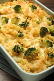 Photo of Tasty pasta casserole with cheese and broccoli in baking dish on table, closeup