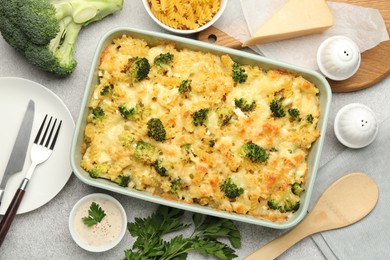 Photo of Tasty pasta casserole with cheese and broccoli served on grey table, flat lay