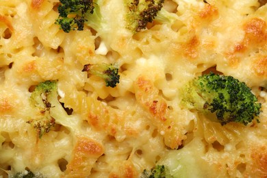 Photo of Tasty pasta casserole with cheese and broccoli as background, top view