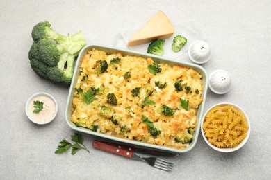 Photo of Tasty pasta casserole with cheese and broccoli served on grey table, flat lay